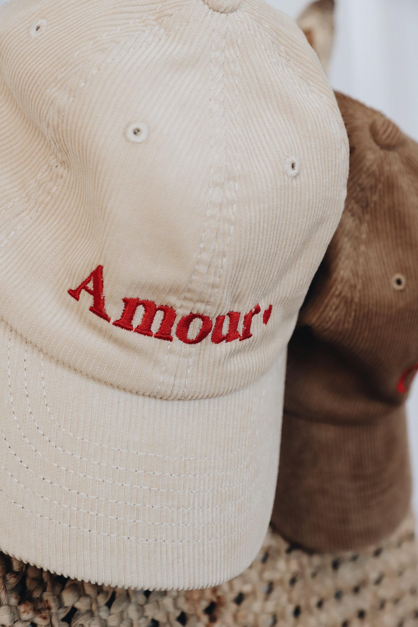 Gros plan de la broderie 'Amour' sur la casquette en velours côtelé.